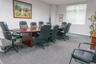 Conference room featuring neutral wall finishes, integrated drop-ceiling lighting, carpeting, and a large window with blind installation