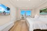 Floor-to-ceiling windows featuring urban skyline imagery, wide-plank wood-finish flooring, recessed ceiling lighting