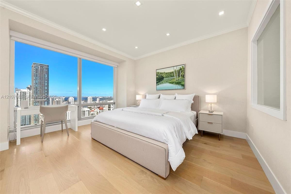 Elegant Primary Bedroom with wallpaper, walk-in closet, and updated bathroom