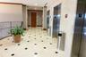 Elevator lobby featuring polished stone flooring with inset accent tiles, stainless steel elevator doors, and neutral wall tiling