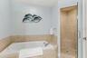 Primary ensiut bathroom with large soaking tub, walk in shower, and private water closet.