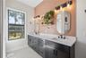 Ceramic tile backsplash all the way up the wall to ceiling in primary bathroom.