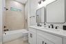 Full bathroom number three with tub/shower combo directly in between bedroom number three and four with dual sinks/vanity space and additional linen c