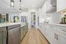 custom cabinetry with 36 inch electric cooktop and sage green oversized island.