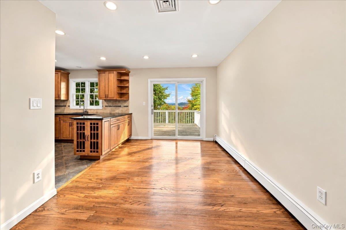 Bright dining room featuring sliding glass doors that open to the deck, where you can enjoy beautiful Hudson River views.
