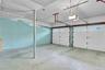 Attached two-car garage featuring dual overhead doors with glass panel inserts, concrete flooring, and ceiling-mounted automatic door openers