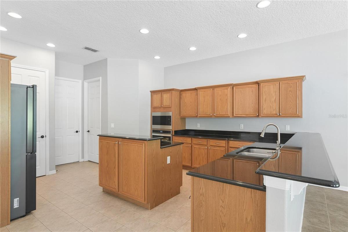 Continuing thru to the kitchen that has updated appliances including an ice maker and wine fridge. This is also open concept to a breakfast nook/dinet