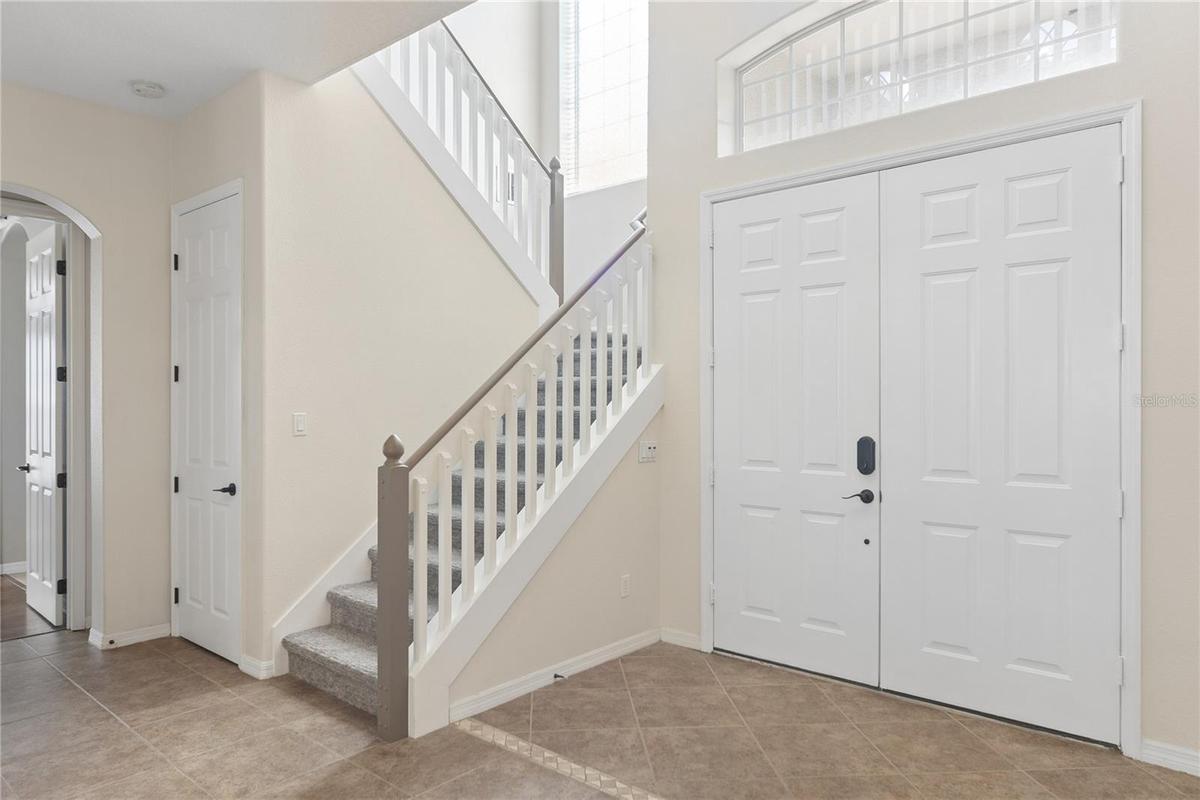 Going thru the double doors into a 2 story foyer and the grand staircase.