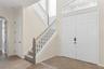 Going thru the double doors into a 2 story foyer and the grand staircase.