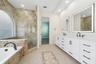 Enjoy this bright and beautifully updated private primary bathroom with garden tub, separate shower, and double vanity with dual sinks.