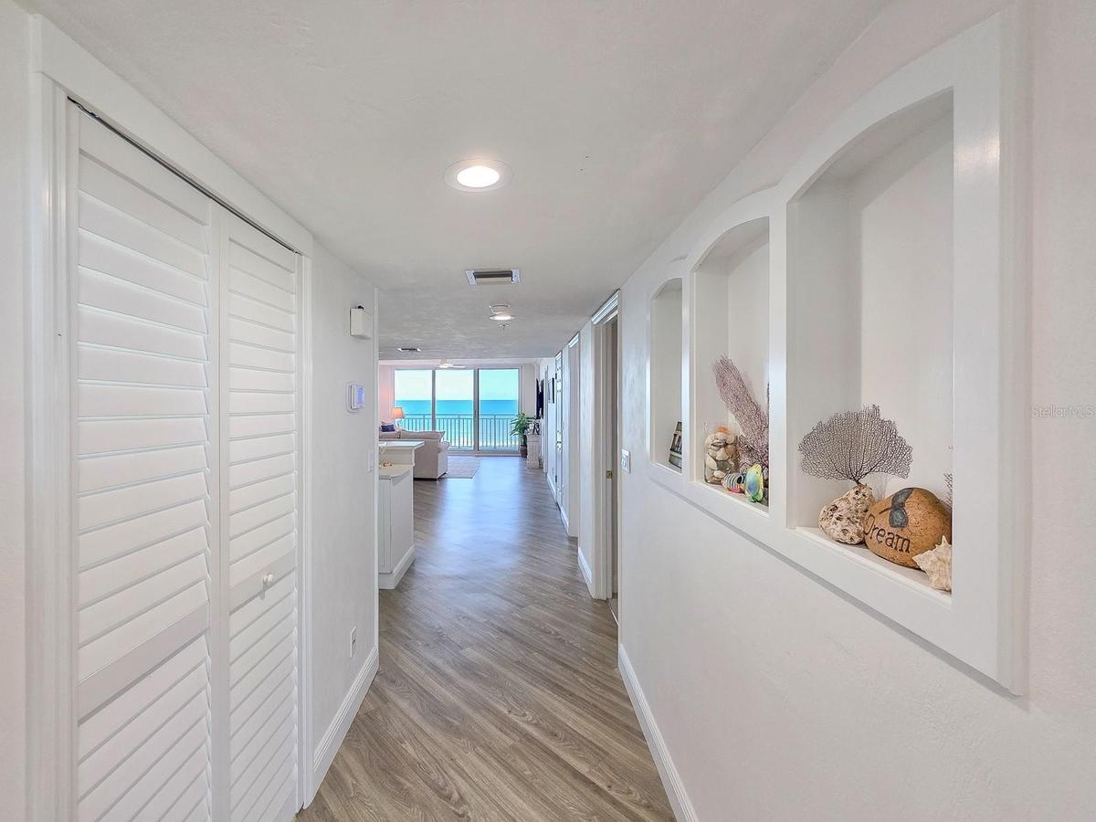 Hallway with laundry on left and built-ins on left.