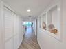 Hallway with laundry on left and built-ins on left.