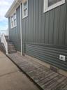 Exterior featuring board-and-batten and horizontal lap siding, white trim, wood-plank decking, and a white railing system