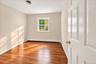 Bright and airy bedroom featuring newly refinished hardwood floors and fresh paint, creating a clean, welcoming feel.