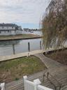 Waterfront property featuring a wood-plank deck, a private bulkhead dock, and mature weeping willow tree