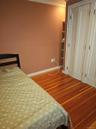 Wood-finish flooring, white paneled bi-fold closet doors, and built-in shelving