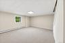 Inviting lower-level family room featuring brand-new carpeting and fresh paint, offering a comfortable space for movie nights, family gatherings, and 