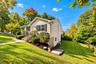 Side yard with neatly maintained landscaping and a freshly painted exterior, offering a welcoming path around to the back of the home.