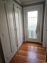 Built-in shaker-style cabinetry, wood-finish flooring, and a glass-panel exterior door with white trim