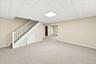 Spacious lower-level family room with a partial view of the adjoining recreation area, offering flexible space for a home office, home gym, hobby room