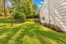 Side yard with neatly maintained landscaping and a freshly painted exterior, offering a welcoming path to the front of the home.