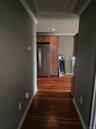 Wood-finish flooring, recessed lighting, crown molding, and wooden cabinetry with a stainless steel refrigerator