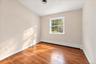 Bright and airy bedroom featuring newly refinished hardwood floors and fresh paint, creating a clean, welcoming feel.