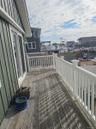 Outdoor deck featuring wood-finish decking, white railings, and attached exterior lighting