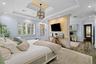 Tray ceiling with recessed lighting and decorative metallic finish, wood-finish flooring, plantation shutters, and central architectural partition wit