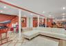 Open-plan room featuring tile flooring, classic columns, recessed lighting, and a mirrored wall