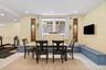 L-shaped built-in bench seating, inset window with stone exterior surround, recessed lighting, and tile flooring