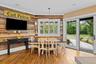 Reclaimed wood accent wall, wood-finish flooring, plantation shutters, and sliding glass doors with exterior access
