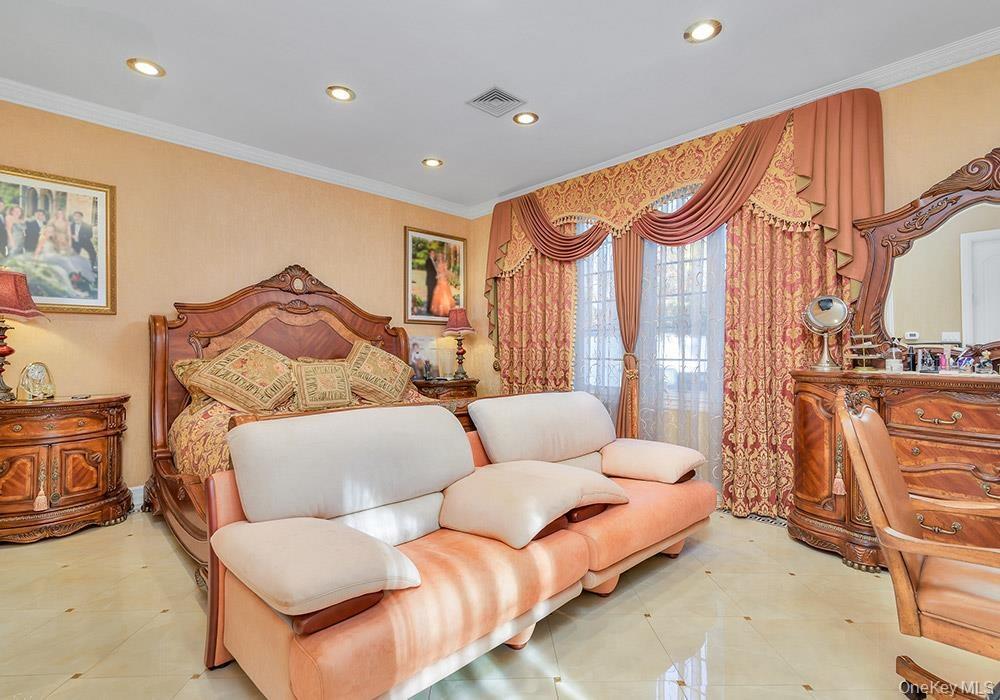 Spacious room featuring recessed lighting, large windows with full-length drapery, and polished tile flooring with decorative inlay accents