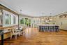 Kitchen featuring a large center island, wood-finish flooring, custom cabinetry, built-in panel-ready refrigerator, and reclaimed wood accent wall