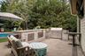 Outdoor kitchen featuring stone masonry, stainless steel built-in grill, stone-slab countertop, integrated storage cabinetry, and paver patio