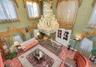 Grand foyer featuring high ceilings, ornate multi-tiered crystal chandelier, stone flooring, and arched double-entry doors