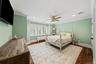 Spacious interior featuring wood-finish flooring, recessed lighting, crown molding, a ceiling fan, and multi-panel plantation shutters