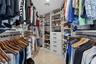 Custom-designed closet with extensive built-in shelving, multiple hanging rods, integrated drawers, an