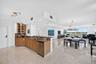 Open-concept living space with polished marble flooring, and extensive windows with motorized blinds