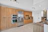 Kitchen featuring light wood cabinetry, stainless steel appliances, granite countertops, a stainless steel sink, and recessed lighting
