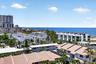 Oceanfront scenery with a distant pier and a mix of residential structures