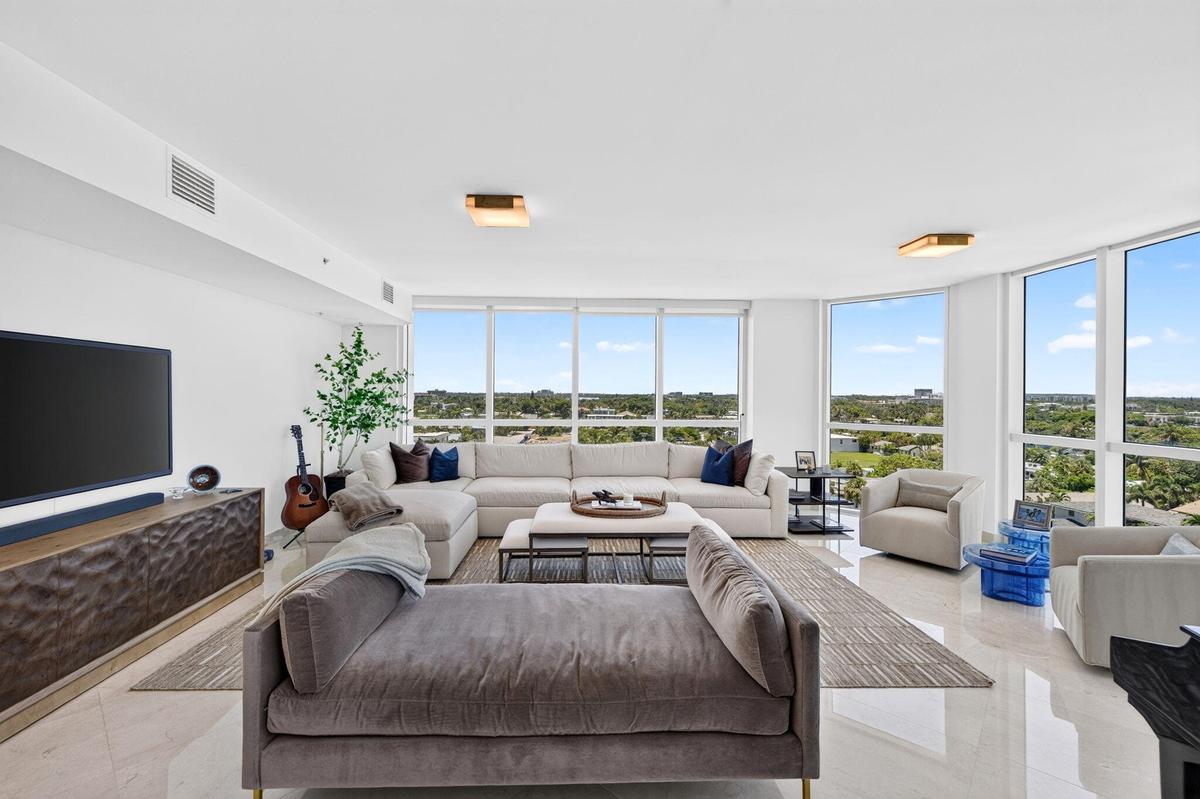 Expansive room featuring floor-to-ceiling windows, recessed lighting, and polished stone flooring