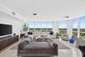 Expansive room featuring floor-to-ceiling windows, recessed lighting, and polished stone flooring