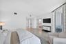 White walls with high ceilings, recessed lighting, and polished stone flooring