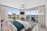 Floor-to-ceiling windows, sliding glass door to exterior balcony, high ceilings, ceiling fan, and marble flooring