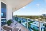 Balcony featuring a glass railing, tiled flooring, and a broad urban landscape