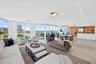 Expansive floor-to-ceiling windows, light-toned tile flooring, open concept layout, wood-finish kitchen cabinetry, and integrated stainless steel appl