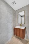 Floating wood-finish vanity with a fluted texture, white integrated sink, and gold-finish faucet
