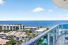 Expansive ocean scenery with a curved balcony featuring glass panel railings and marble flooring