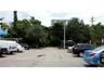 Paved surface lot featuring mature perimeter landscaping and an integrated utility pole